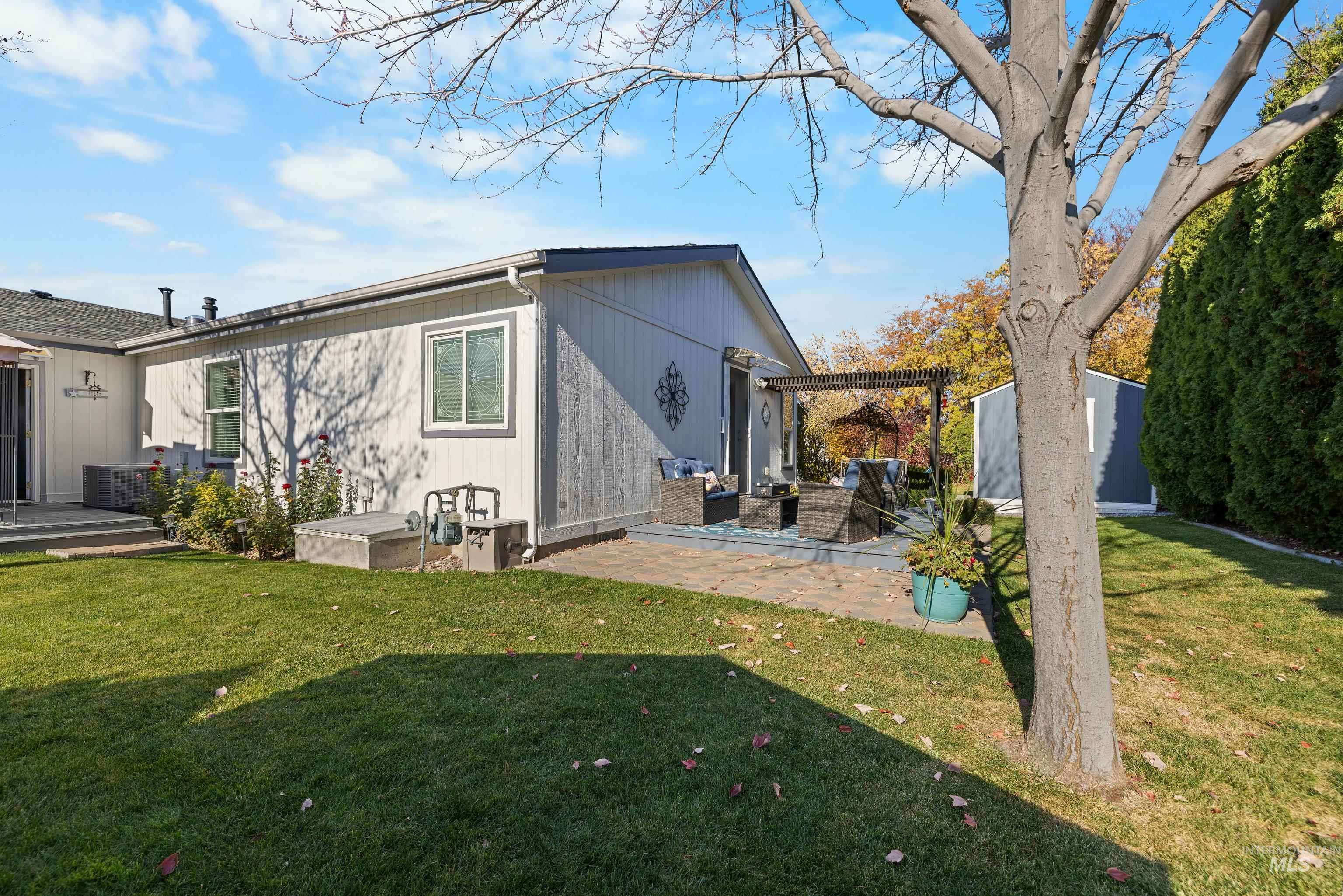 Rear view of house with a yard, a patio area, and an outdoor structure