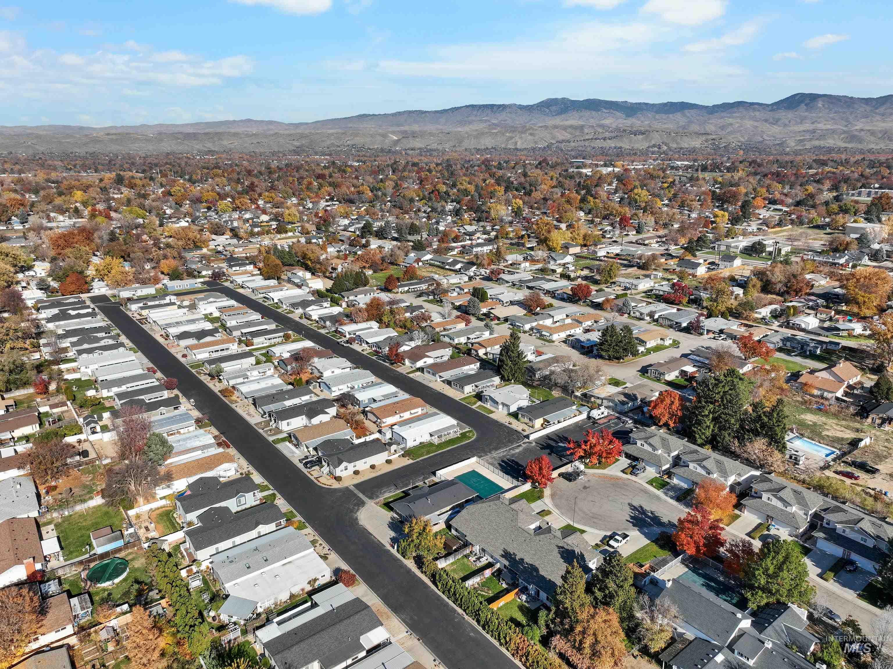 Aerial view of property's location with a mountainous background and nearby suburban area