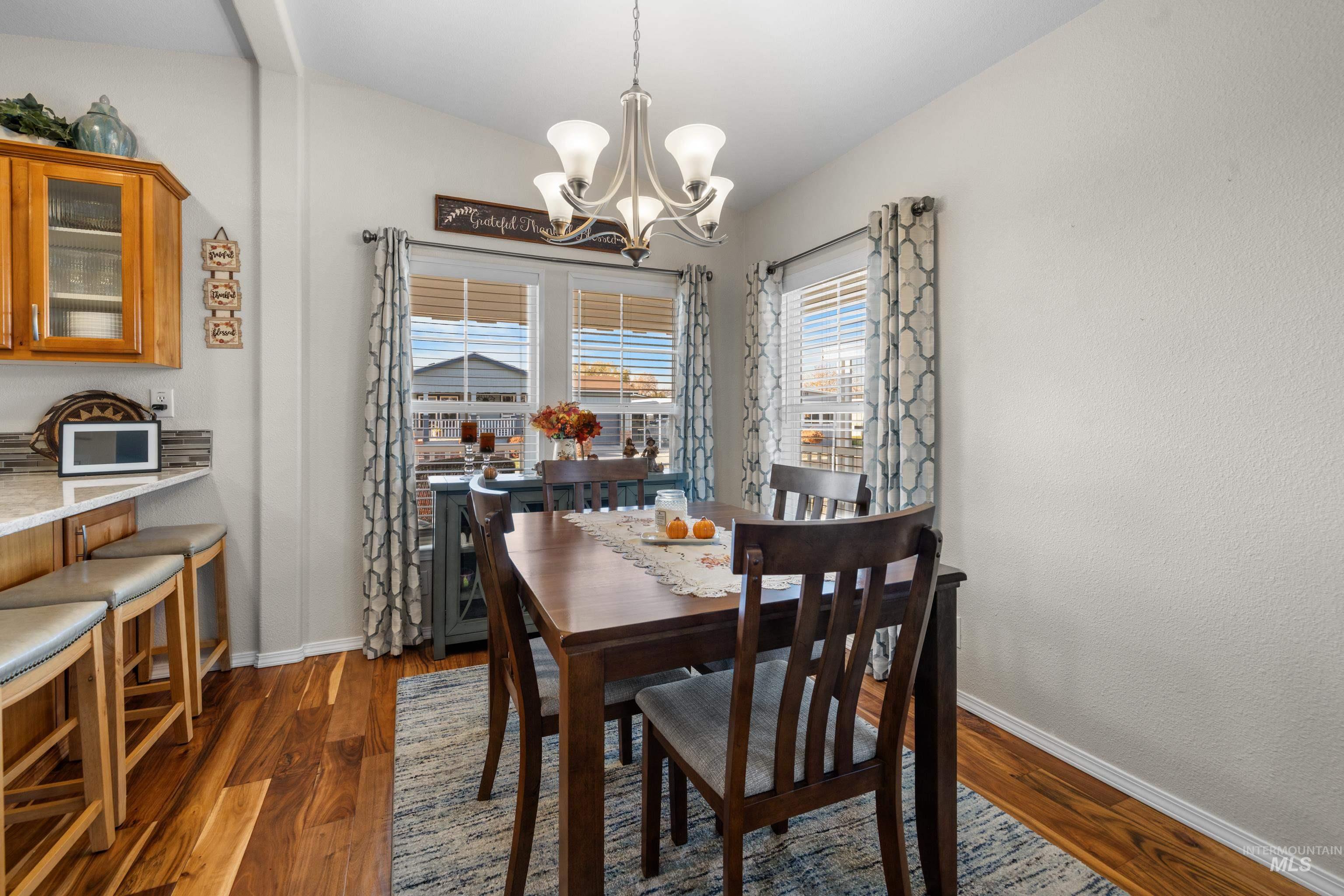 Dining space with dark wood-style floors and a chandelier