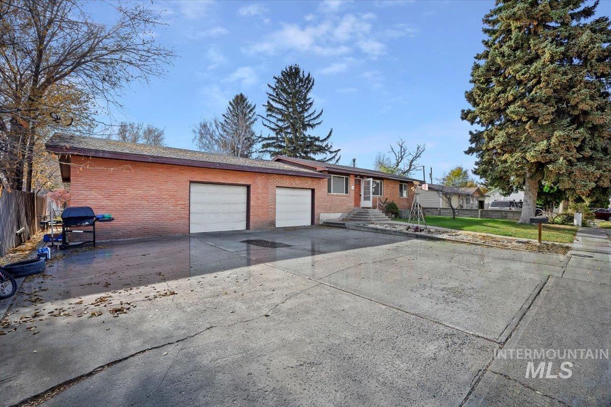 Single story home featuring concrete driveway, brick siding, and an attached garage