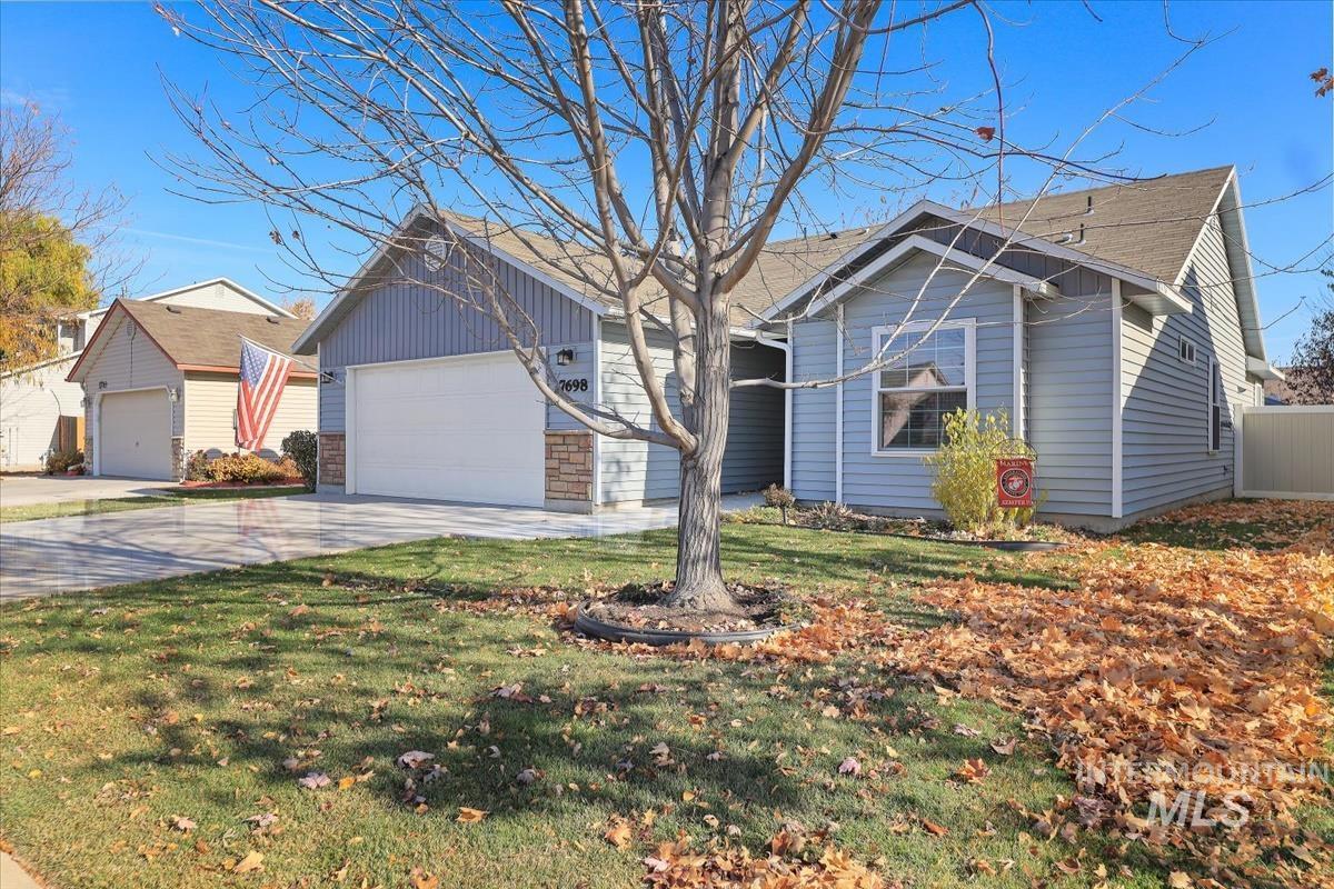 Ranch-style home with an attached garage, driveway, and a front lawn