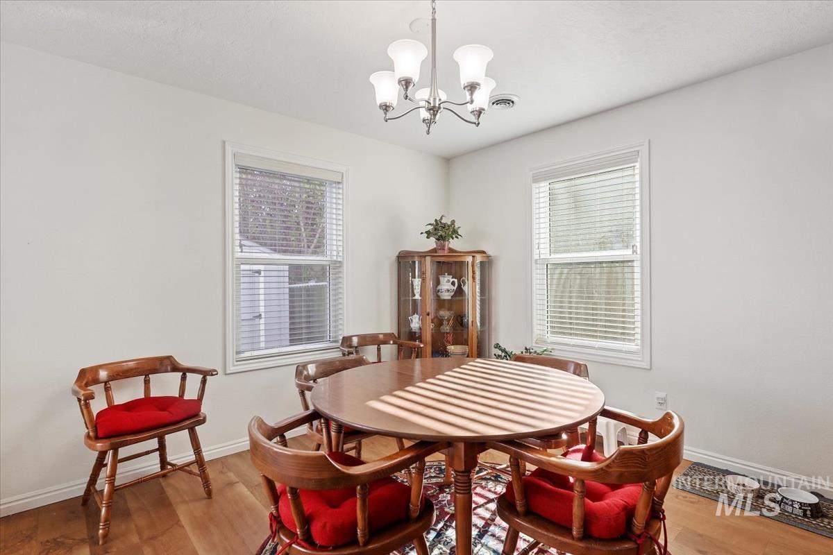 Dining room with wood finished floors and a chandelier
