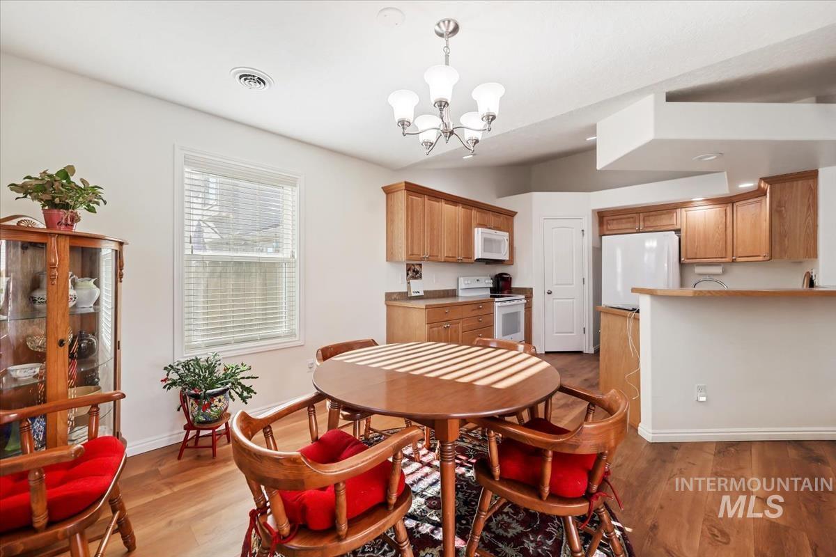 Dining room with light wood-type flooring and a chandelier