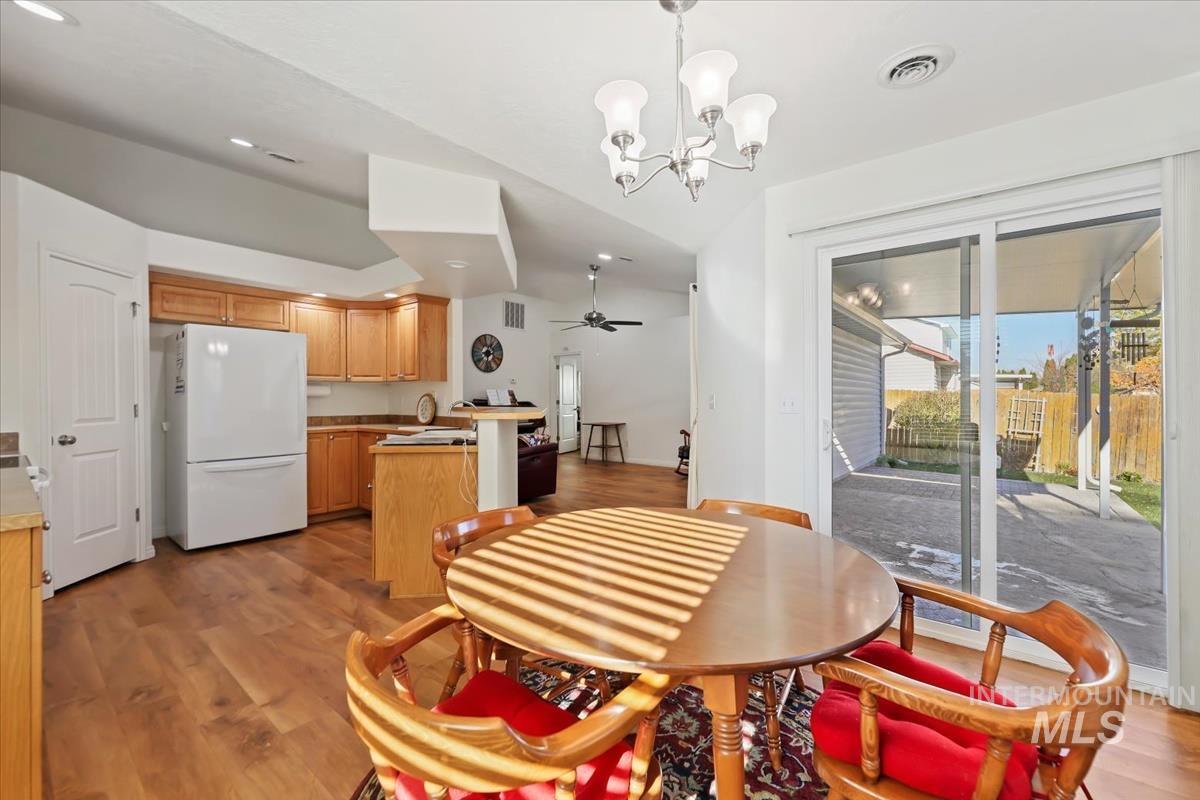 Dining space featuring light wood finished floors, a chandelier, ceiling fan, and recessed lighting