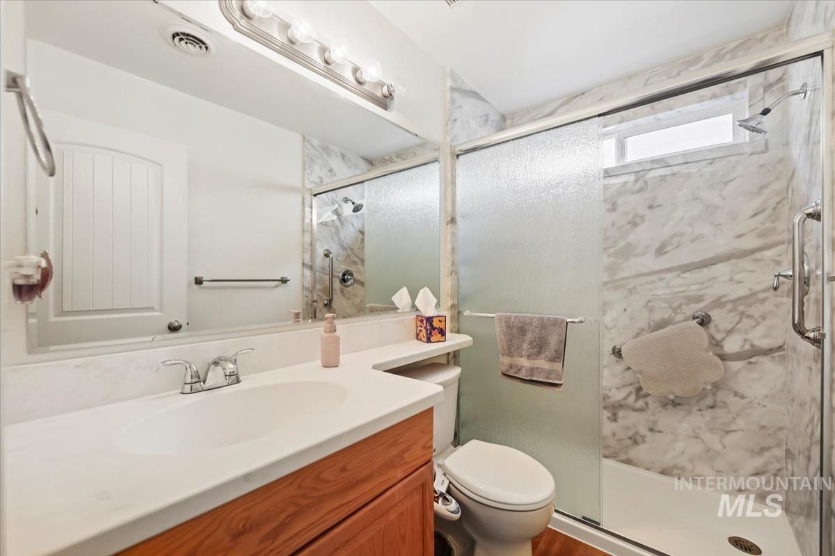 Bathroom with vanity and a marble finish shower