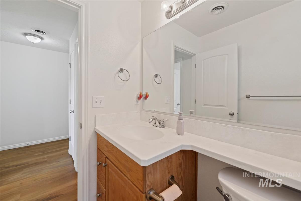 Half bathroom featuring vanity and wood finished floors