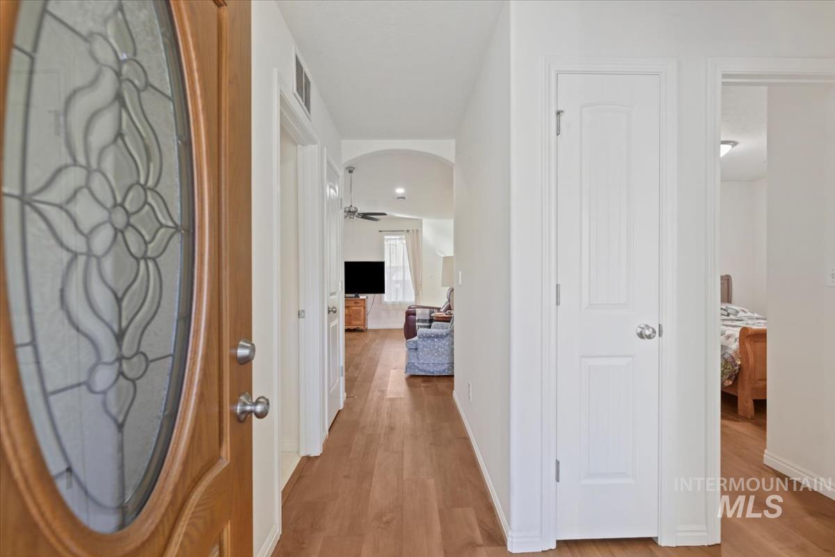 Hallway featuring light wood-style flooring and arched walkways