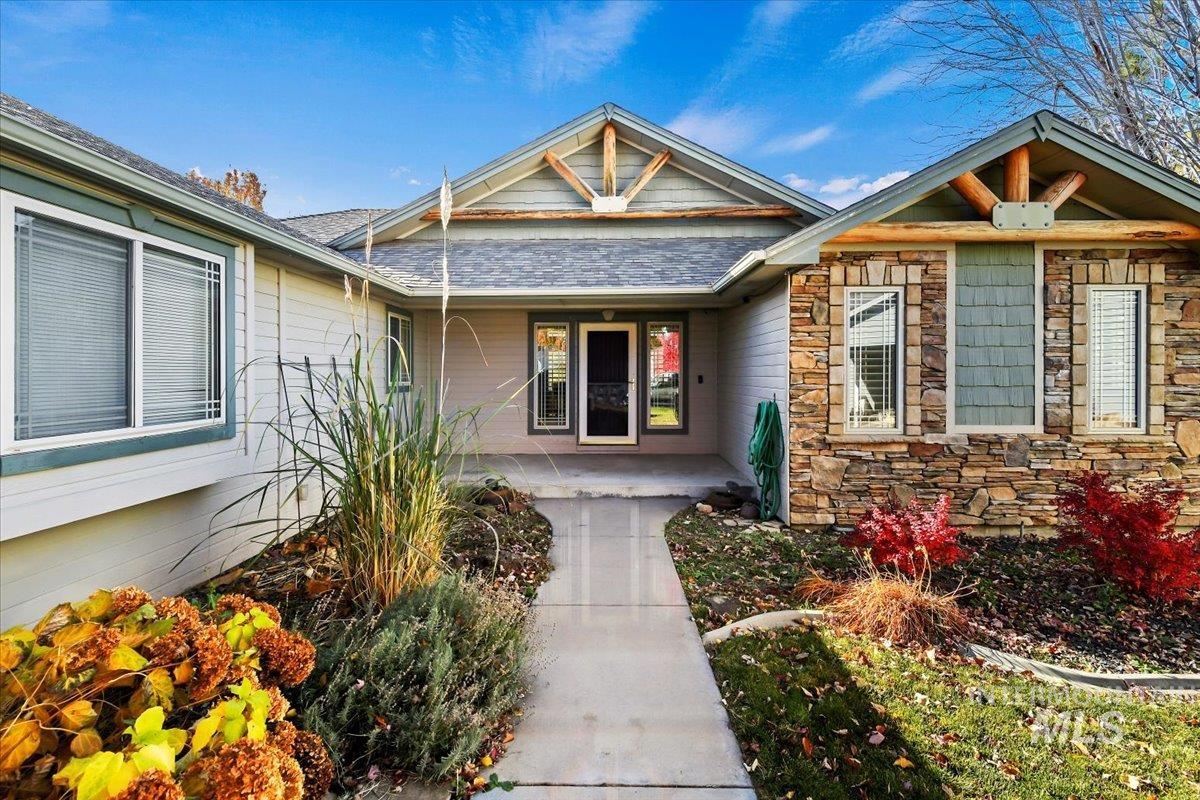 Doorway to property featuring covered porch and stone siding