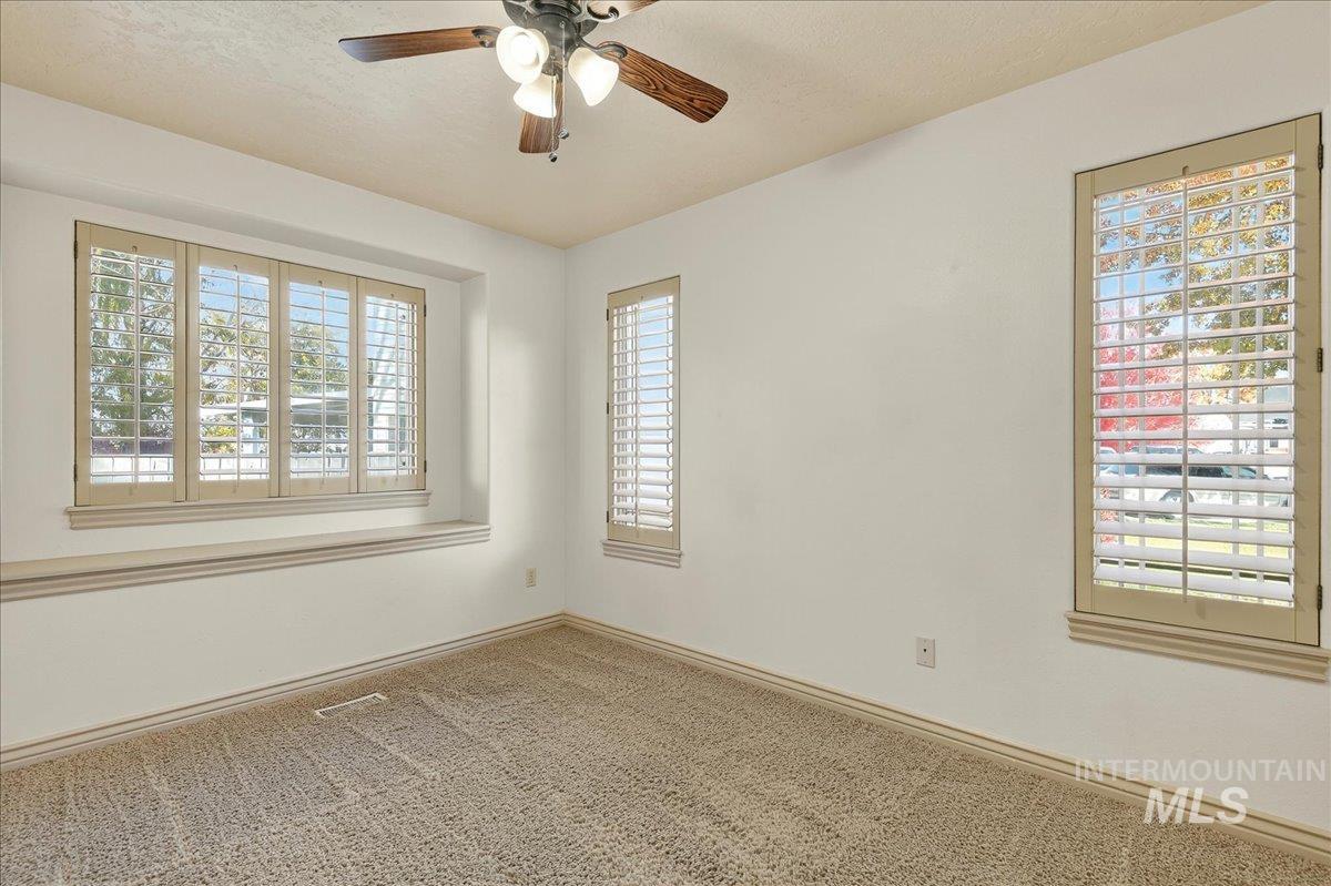 Carpeted spare room featuring ceiling fan and a textured ceiling