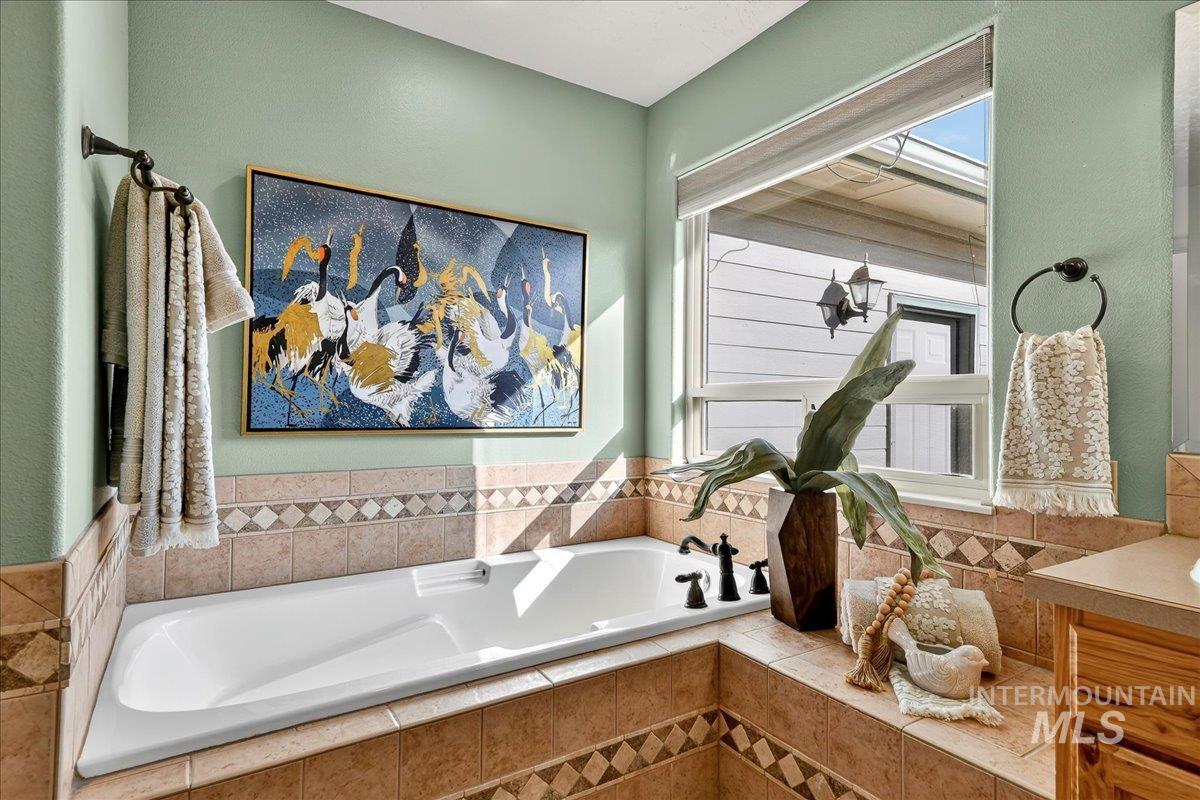 Full bath with a garden tub and vanity