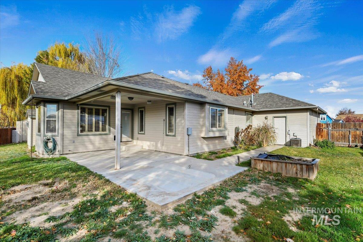 Rear view of house with a patio area and a shingled roof