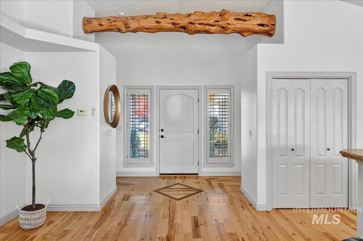Foyer entrance with light wood finished floors and baseboards