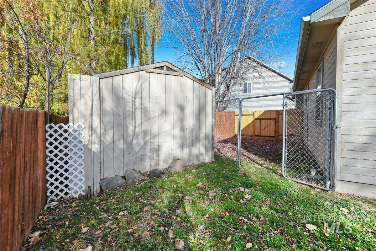 View of shed with a fenced backyard and a gate