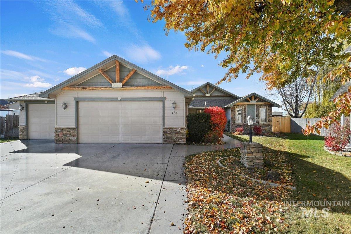 Craftsman house with stone siding, driveway, and an attached garage