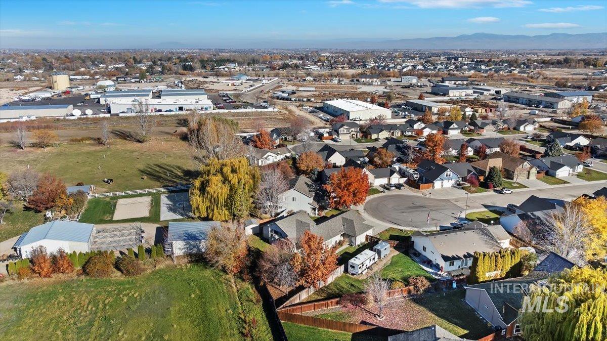 Aerial view of property and surrounding area with nearby suburban area