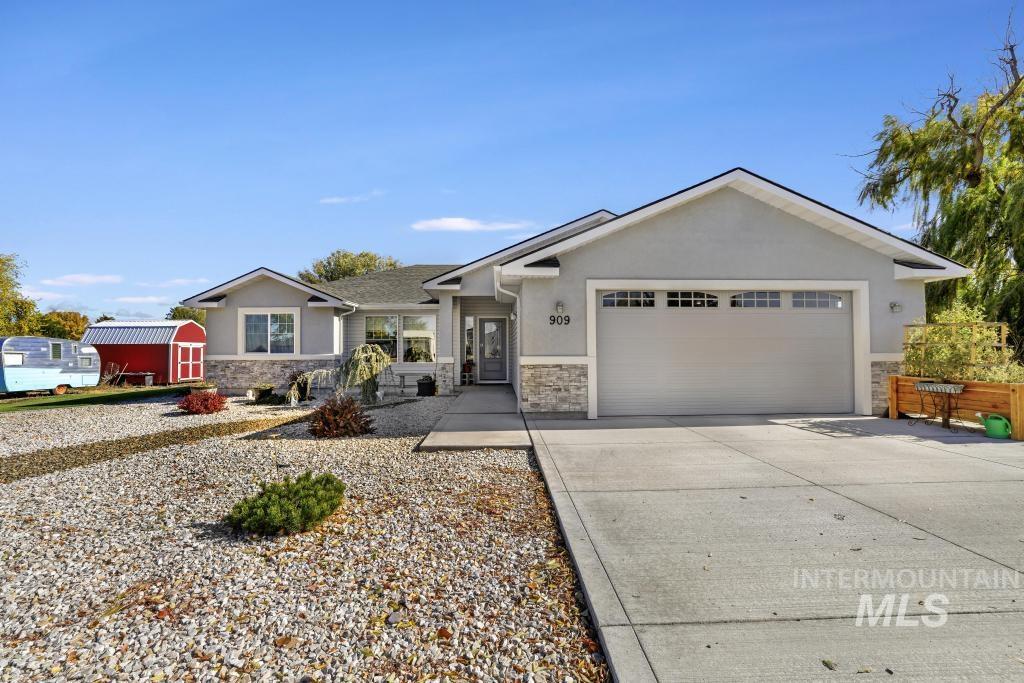 Single story home featuring stone siding, concrete driveway, stucco siding, and an attached garage
