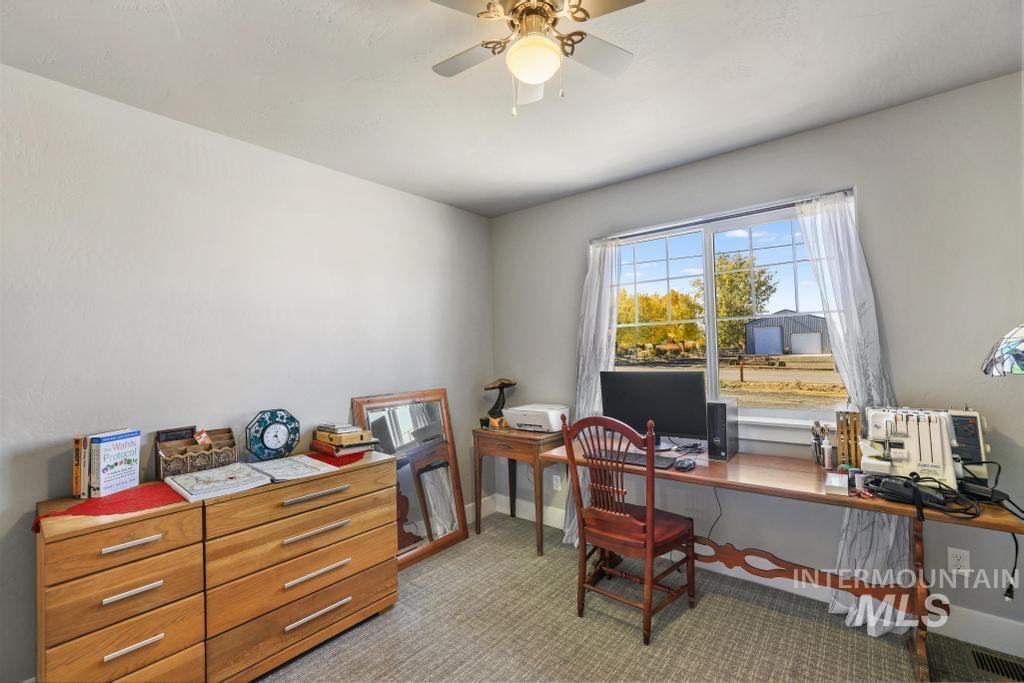 Office area with light carpet and a ceiling fan