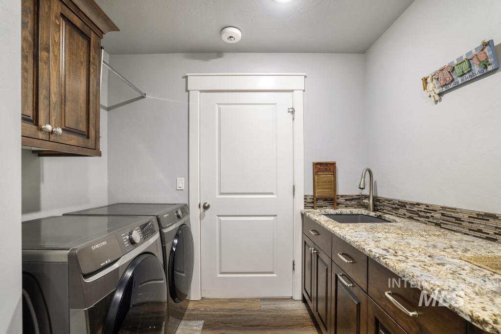 Laundry room with dark wood finished floors, cabinet space, and separate washer and dryer