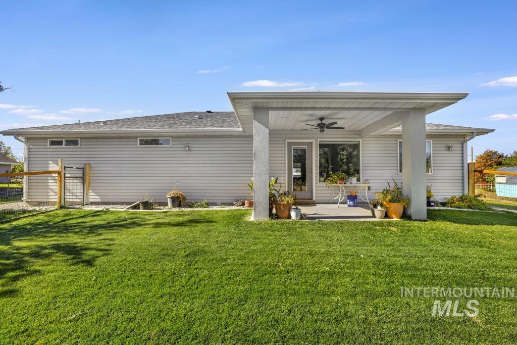 Back of property featuring a ceiling fan, a patio area, and a shingled roof