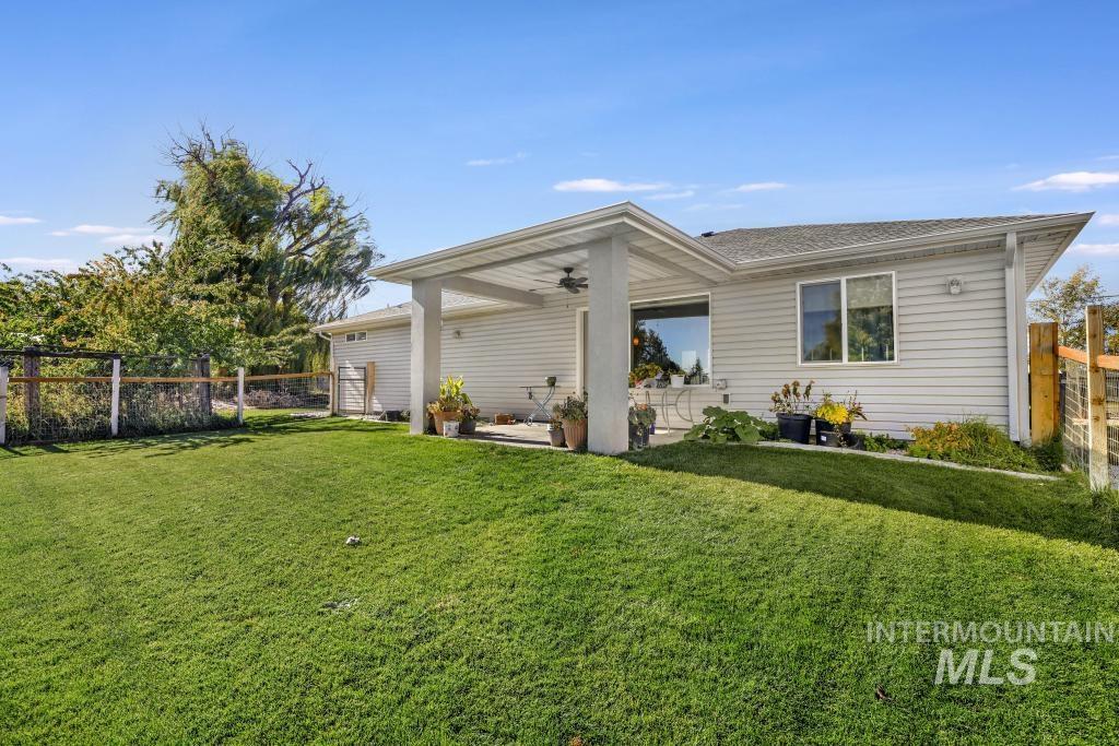 Back of property with a fenced backyard, a ceiling fan, and roof with shingles