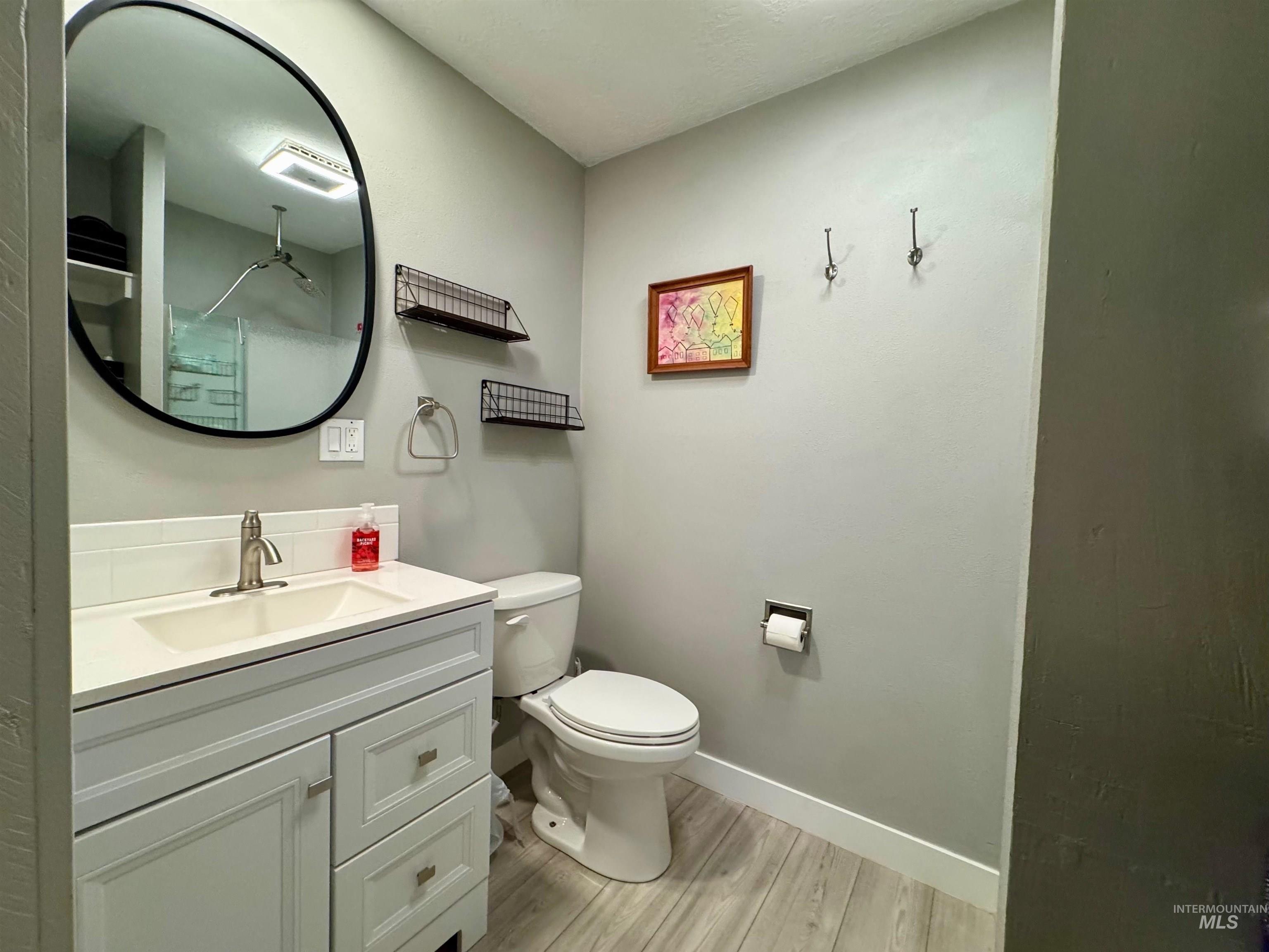 Bathroom with vanity, light wood-style floors, and a shower