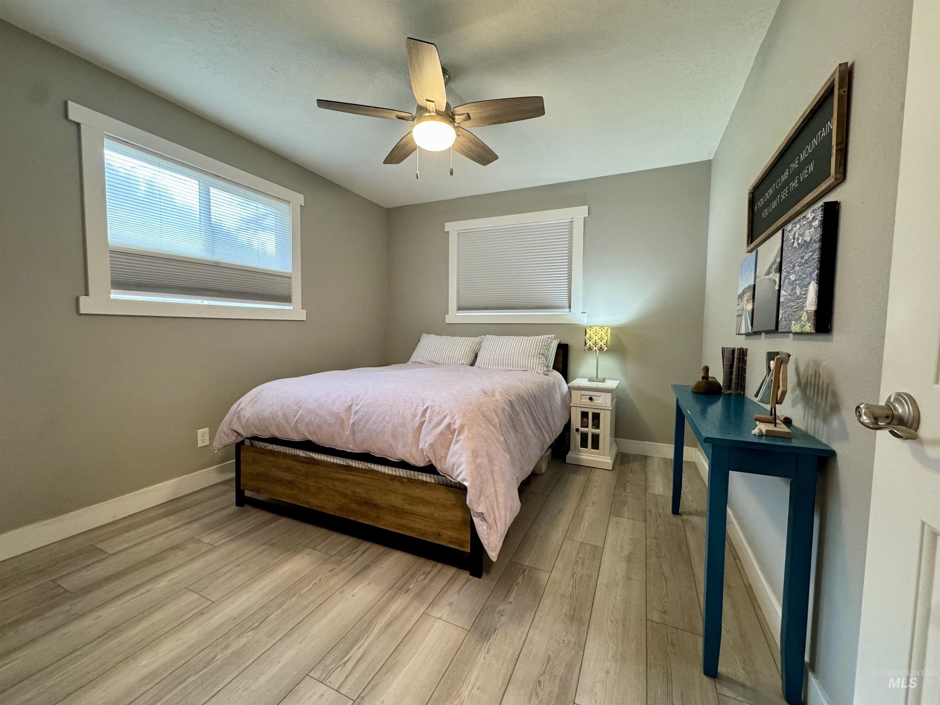 Bedroom with a ceiling fan and light wood-style flooring