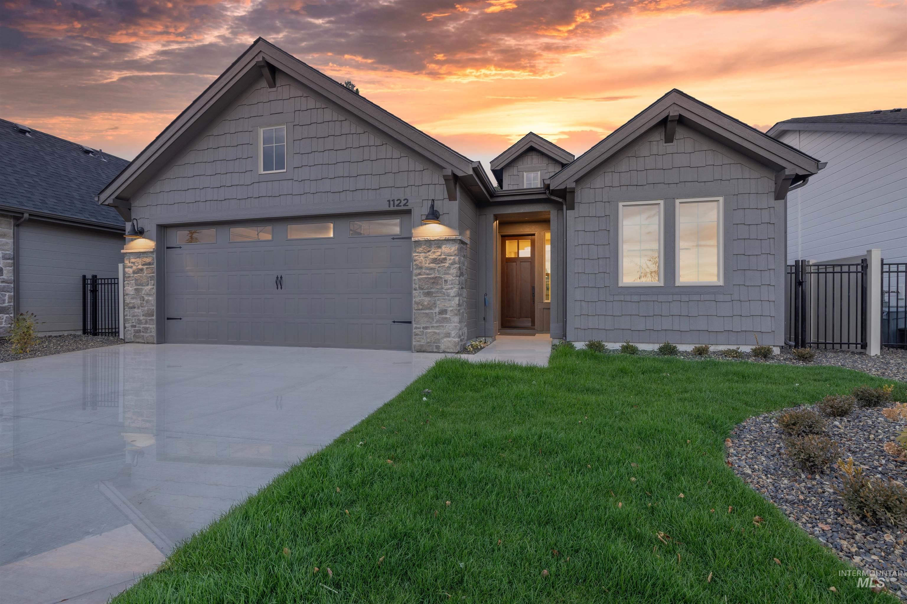 View of front of home featuring concrete driveway, stone siding, and an attached garage