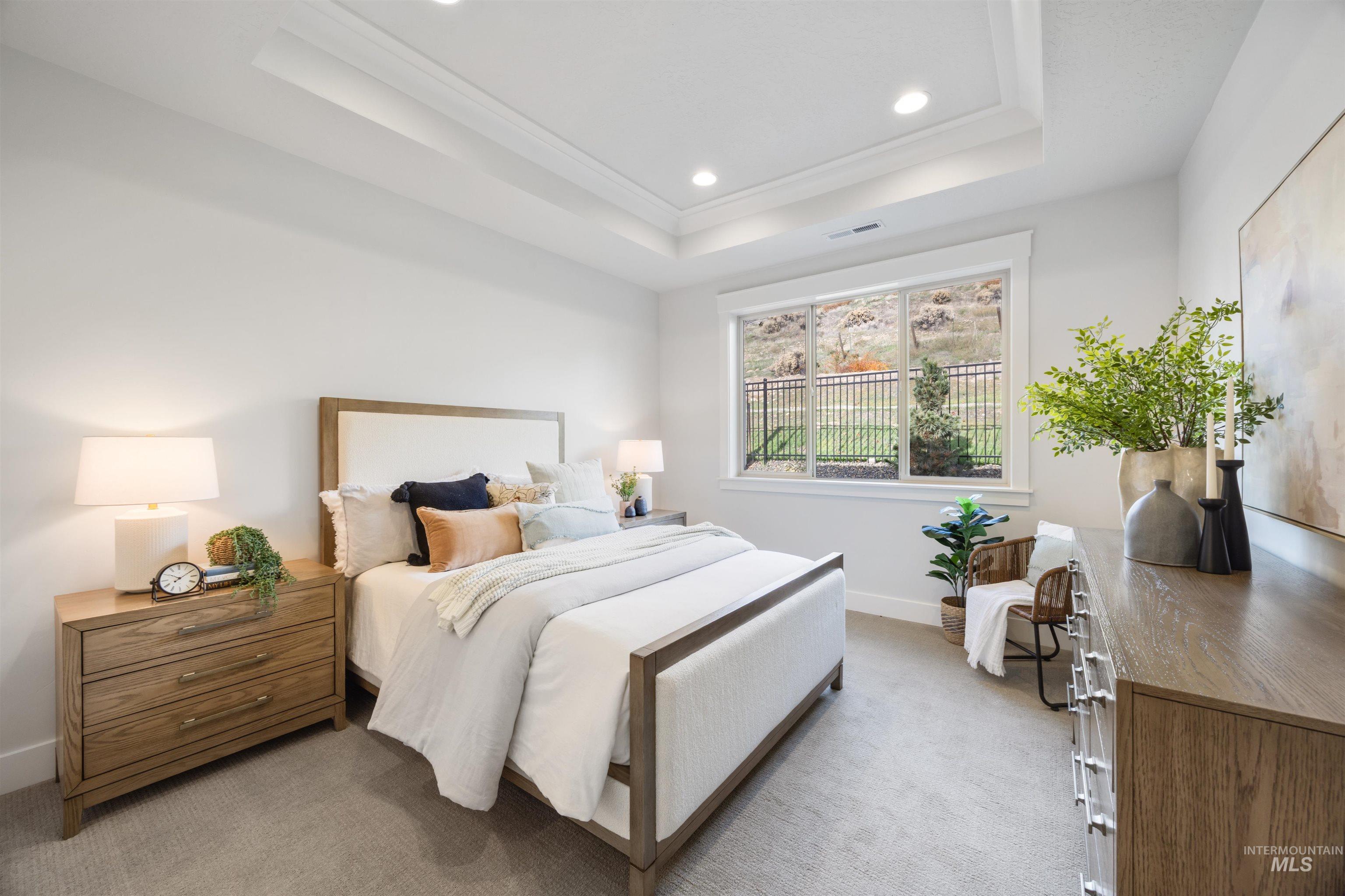 Bedroom featuring light carpet, recessed lighting, a tray ceiling, and ornamental molding
