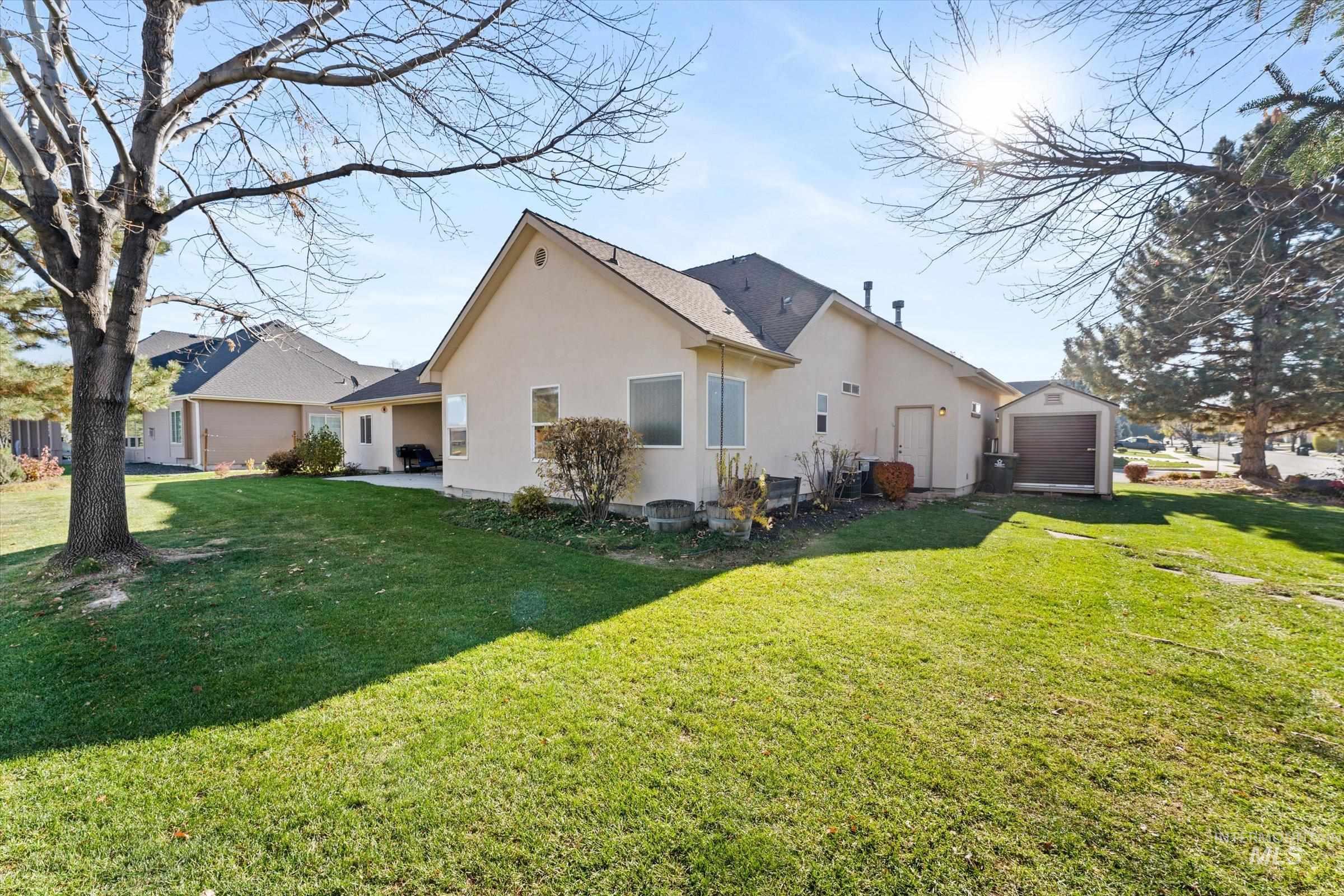 View of side of property with stucco siding, a lawn, and a patio area