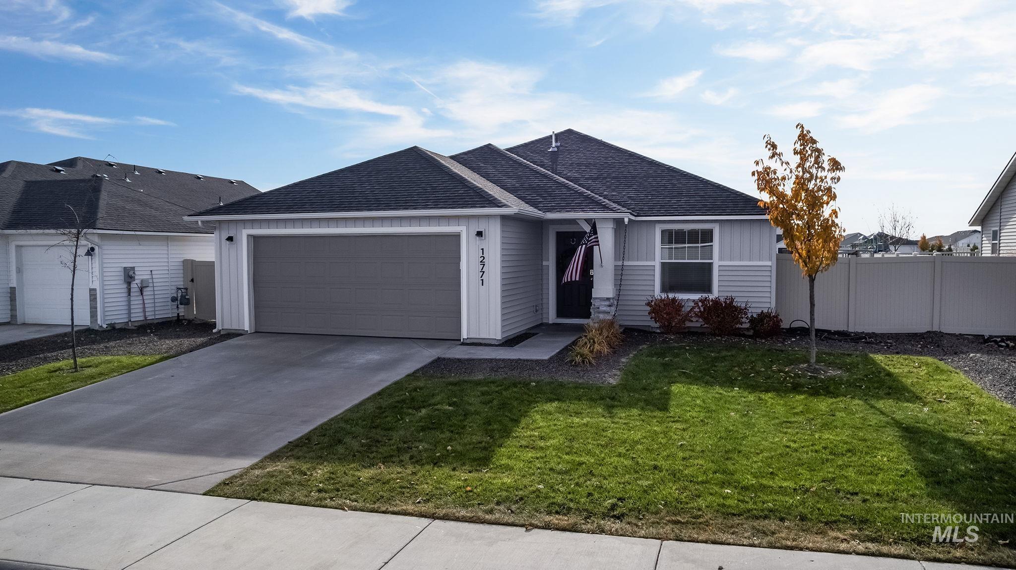 Ranch-style home featuring roof with shingles, concrete driveway, and a garage