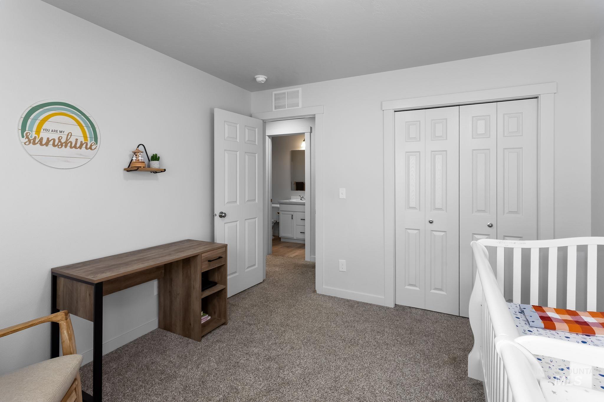 Carpeted bedroom with a closet and baseboards