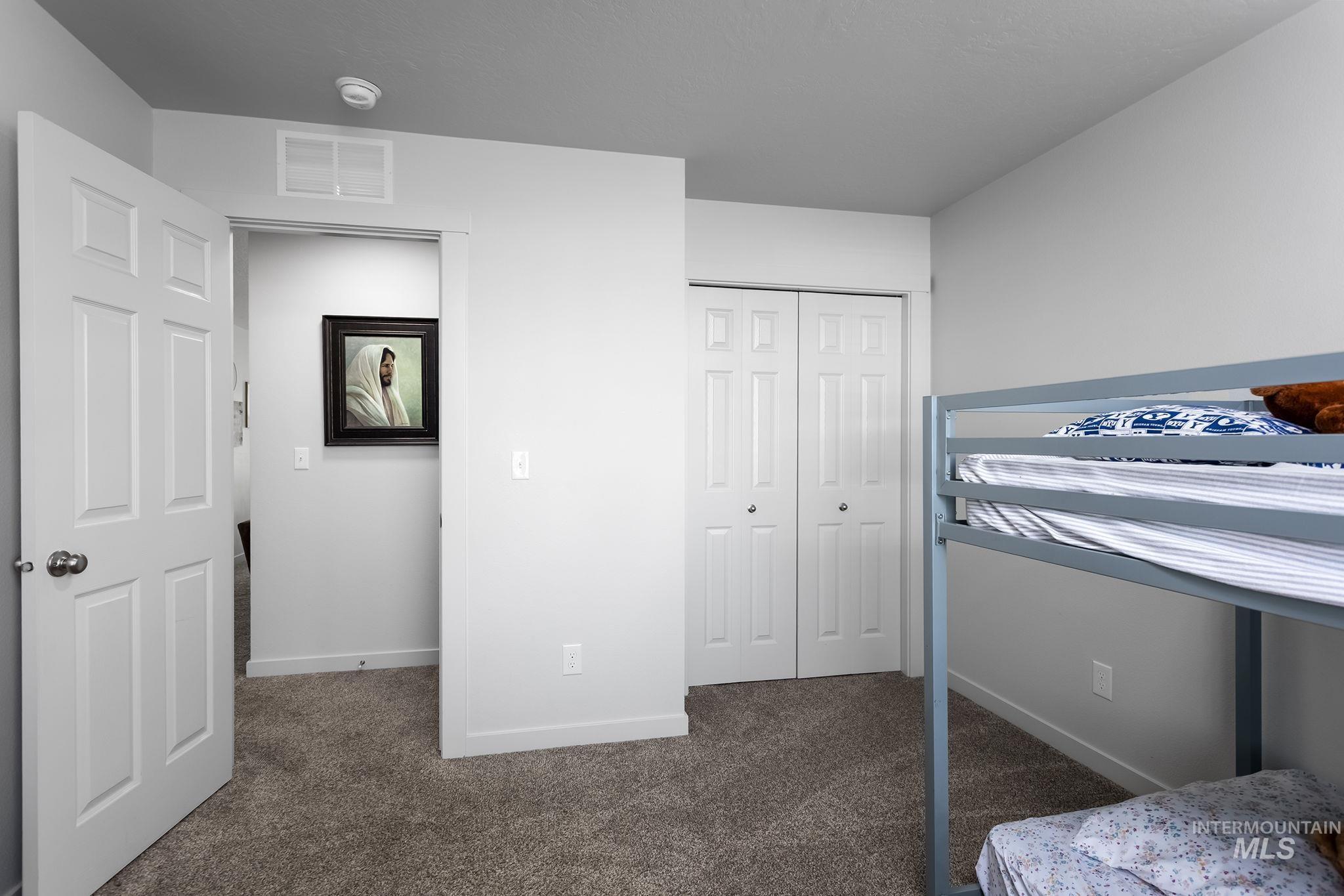 Bedroom with dark colored carpet and a closet