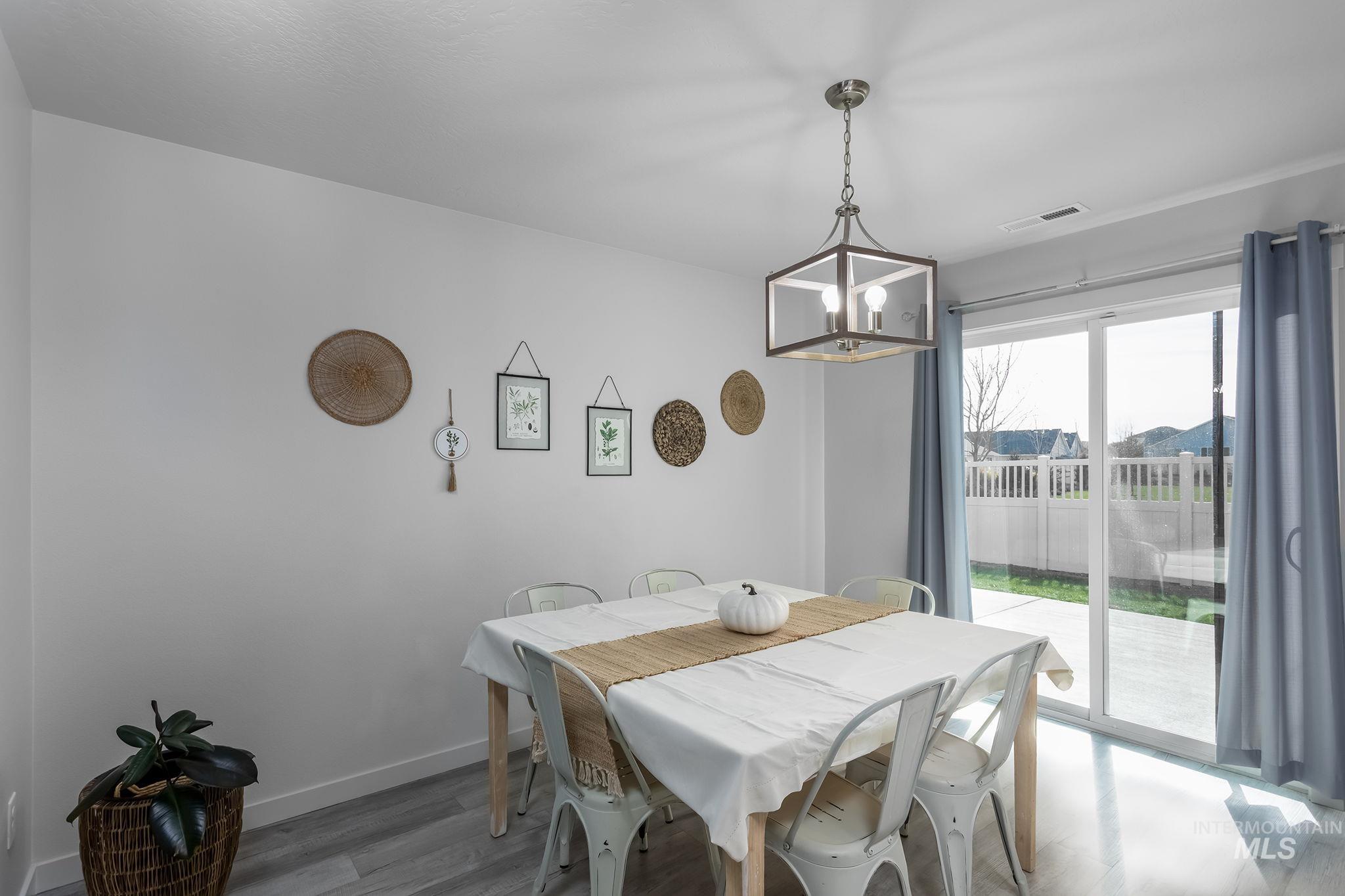 Dining space featuring wood finished floors and a chandelier