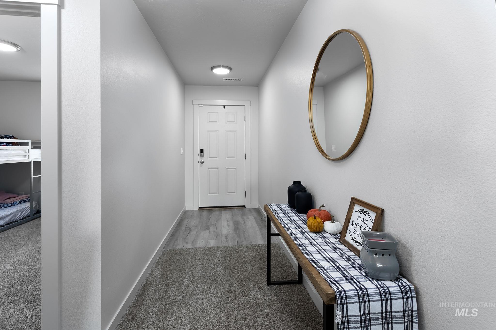 Doorway featuring baseboards and carpet