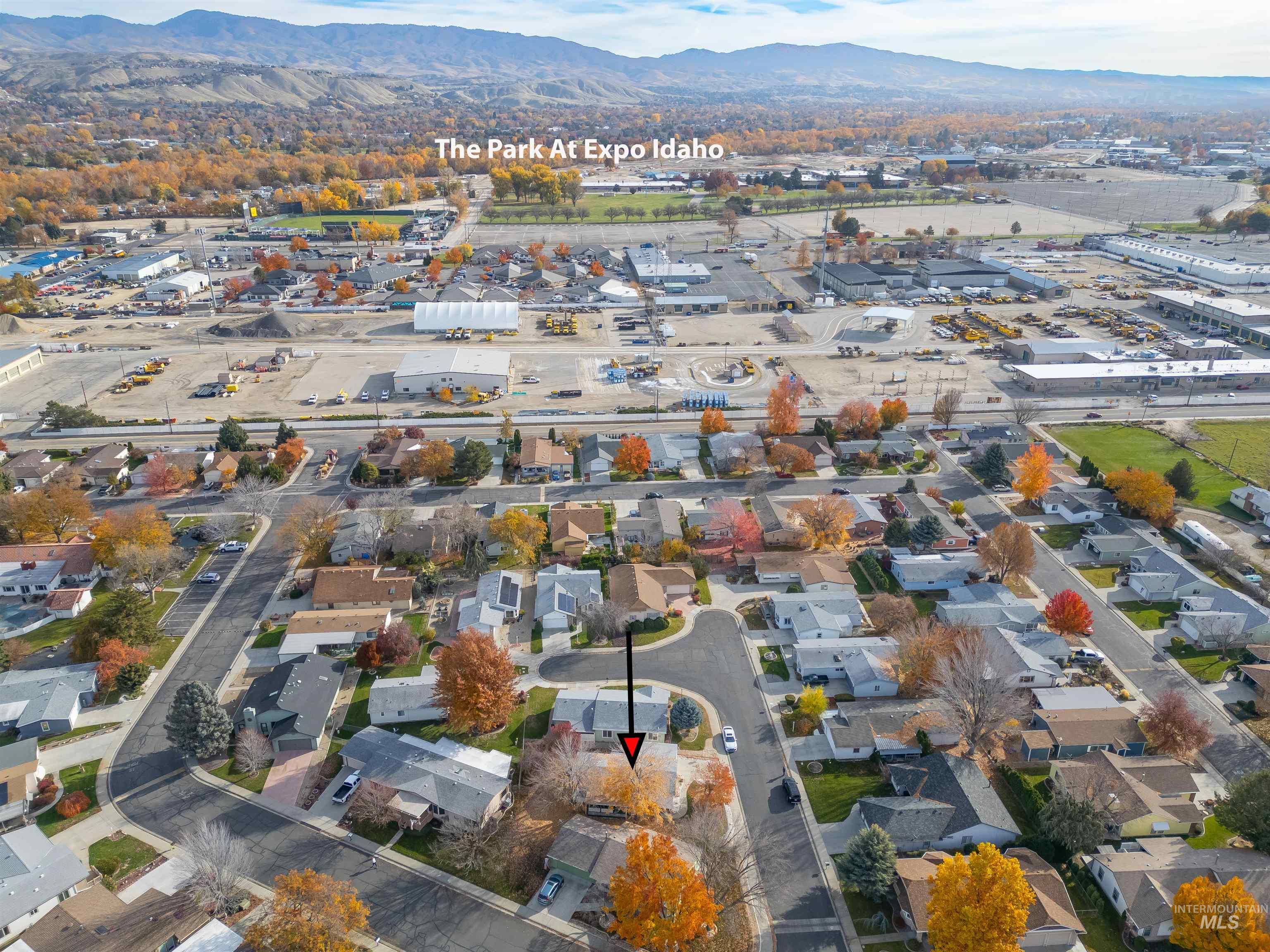 Aerial view of property and surrounding area with a mountainous background and nearby suburban area