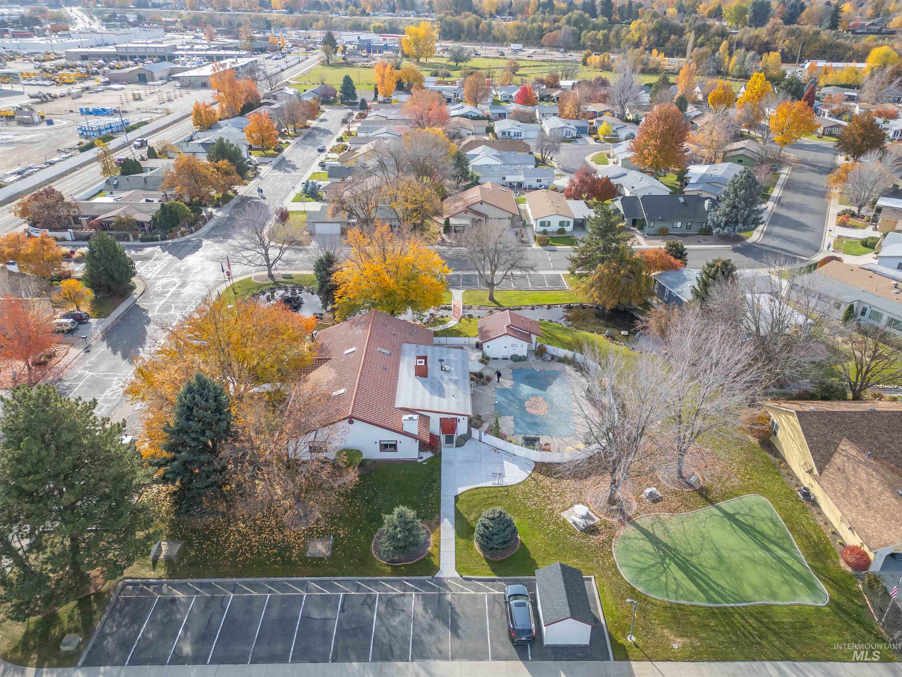 Aerial view community common areas, including putting green,  pond, pool, hot tub,  pickle ball courts, tennis court and clubhouse.