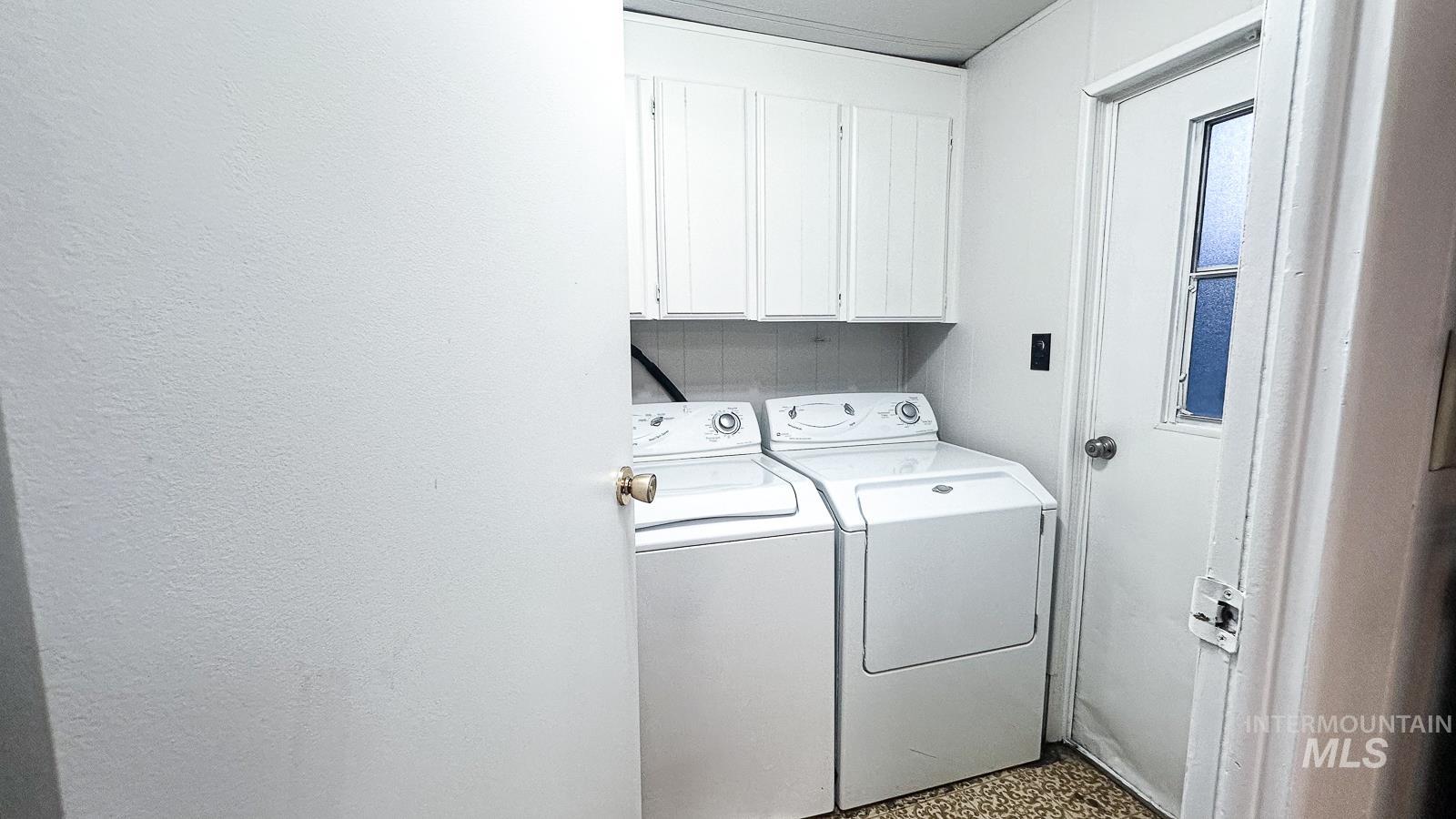 Washroom with cabinet space, washer and clothes dryer, and speckled floor