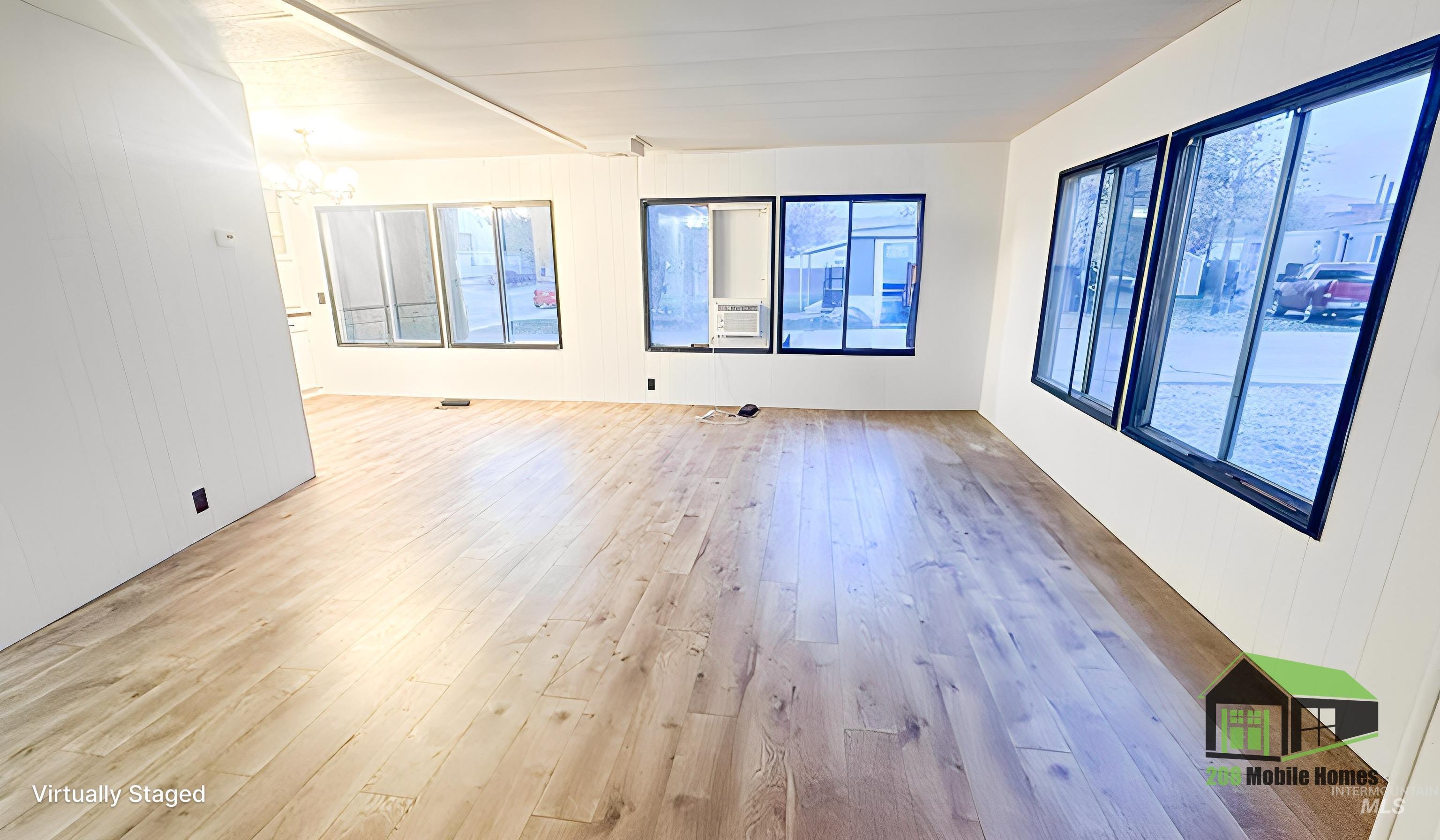 Empty room featuring hardwood / wood-style floors, wood walls, a chandelier, and cooling unit