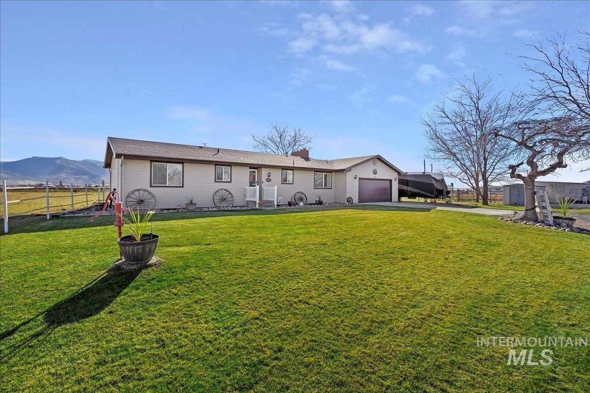 Ranch-style home with driveway, a garage, a chimney, and a mountain view