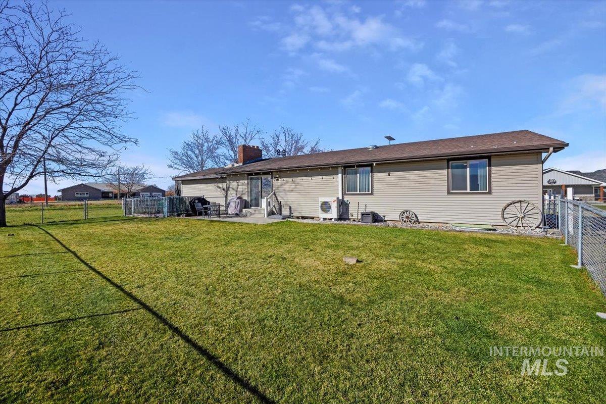 Rear view of property with a fenced backyard, a patio, and a chimney