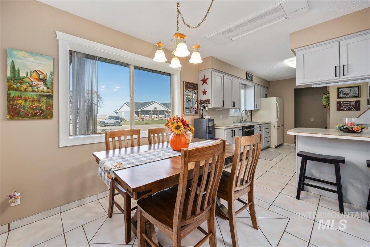 Dining space with light tile patterned floors and a chandelier