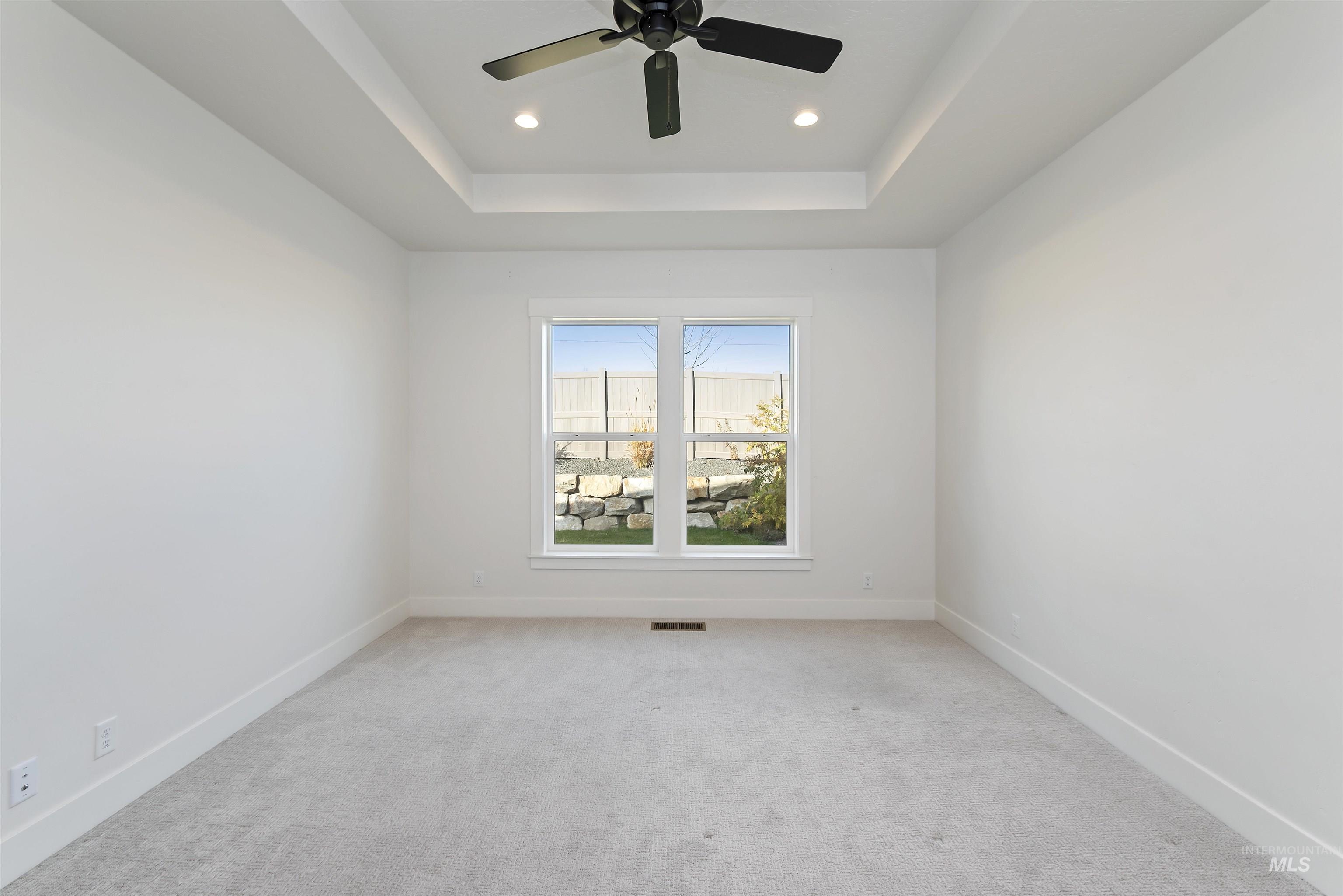 Carpeted spare room with recessed lighting, a raised ceiling, and ceiling fan