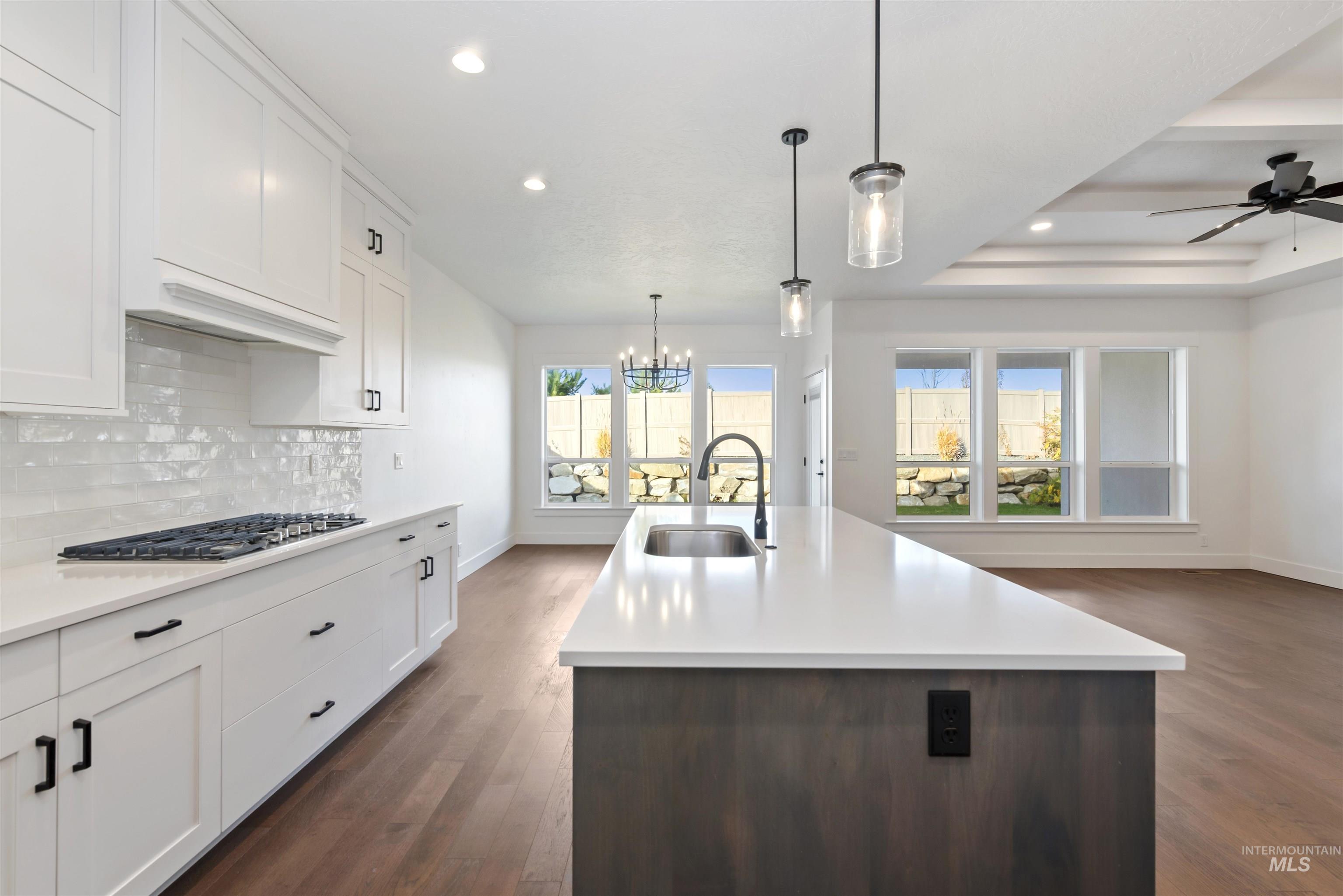 Kitchen featuring white cabinetry, pendant lighting, open floor plan, dark wood-style floors, and recessed lighting