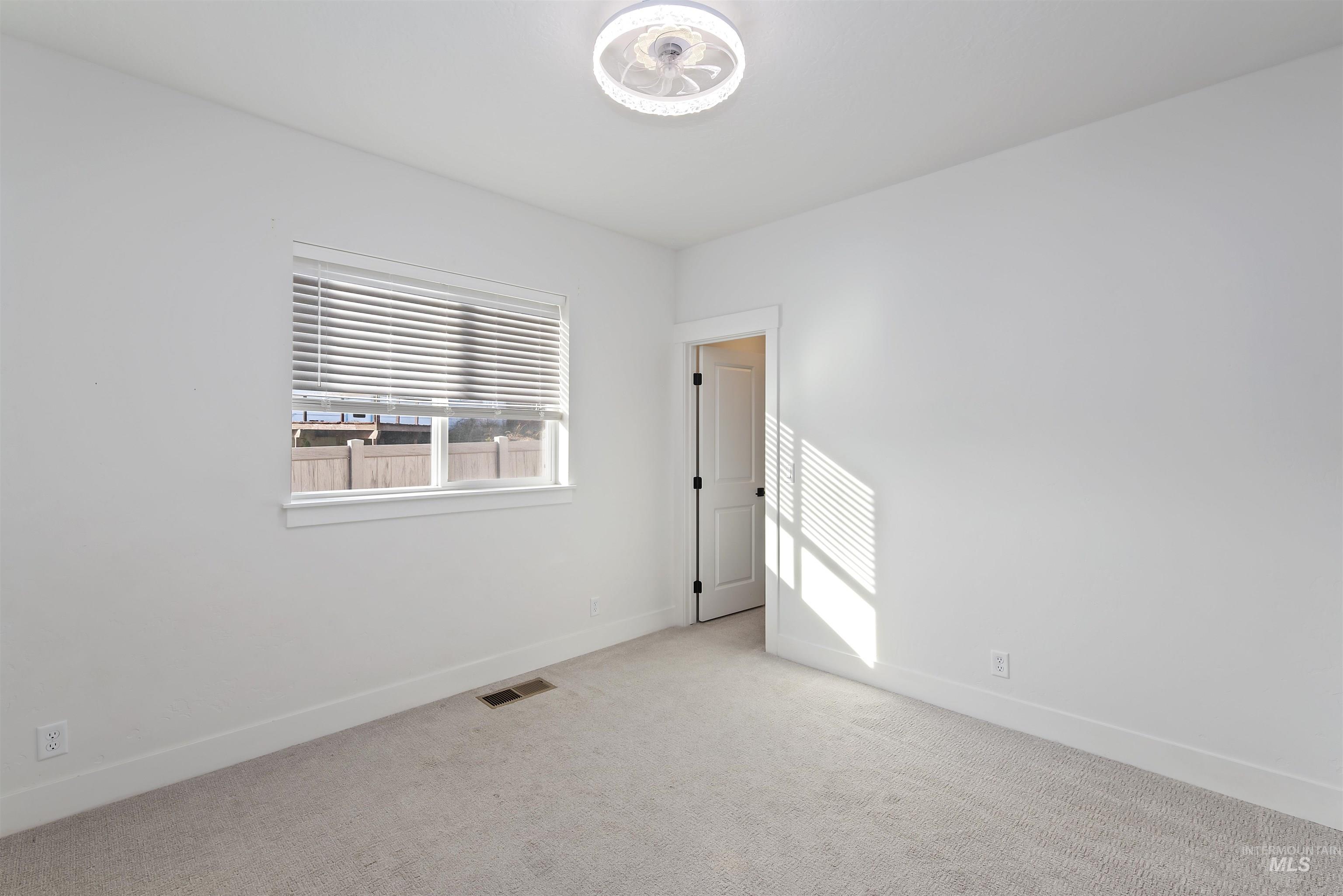 Carpeted spare room featuring baseboards