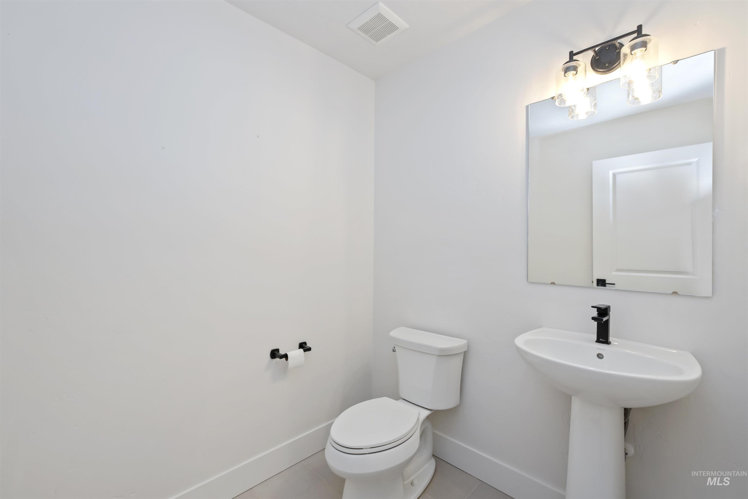 Half bath with tile patterned flooring and baseboards