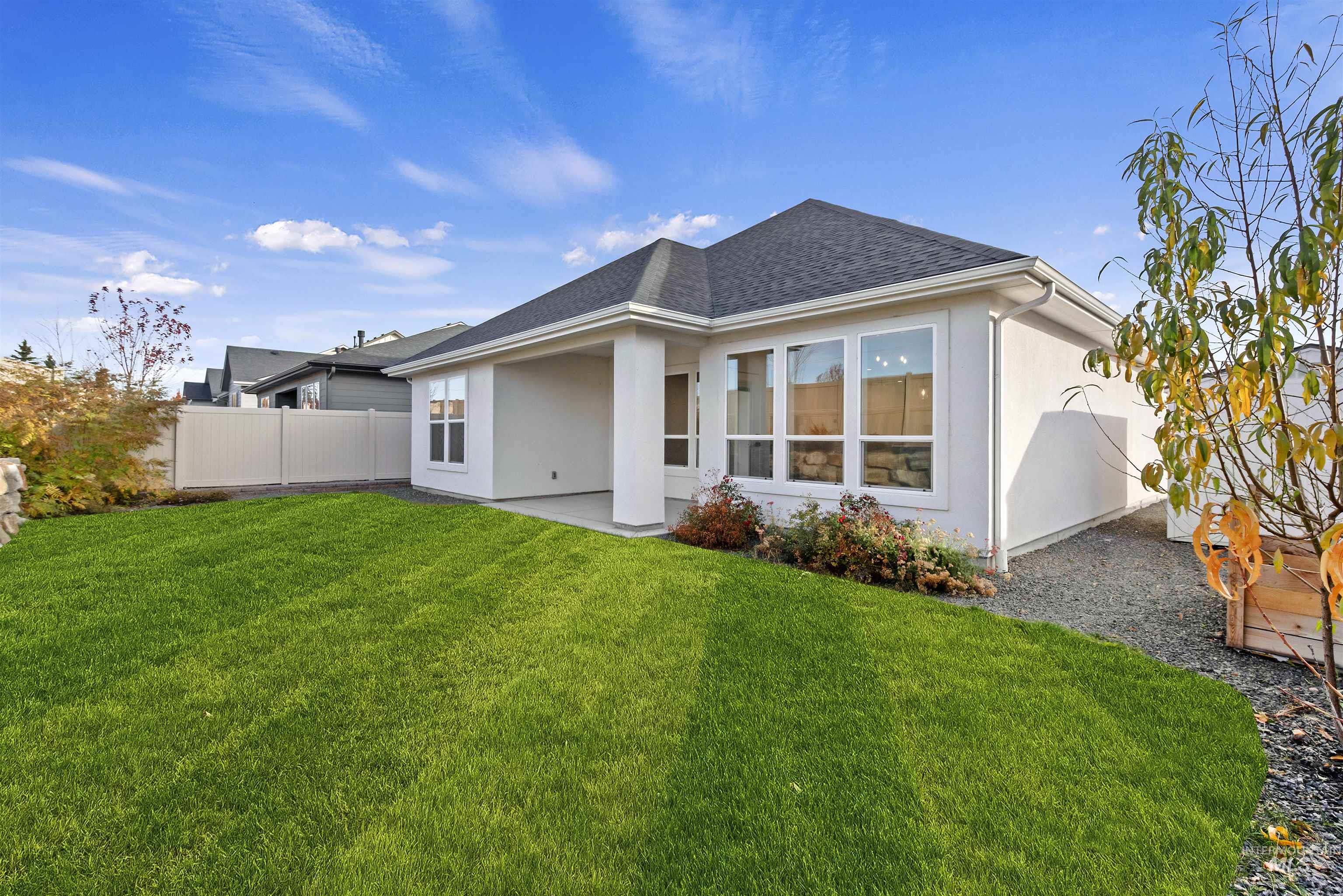 Back of house featuring a shingled roof, a patio, and stucco siding