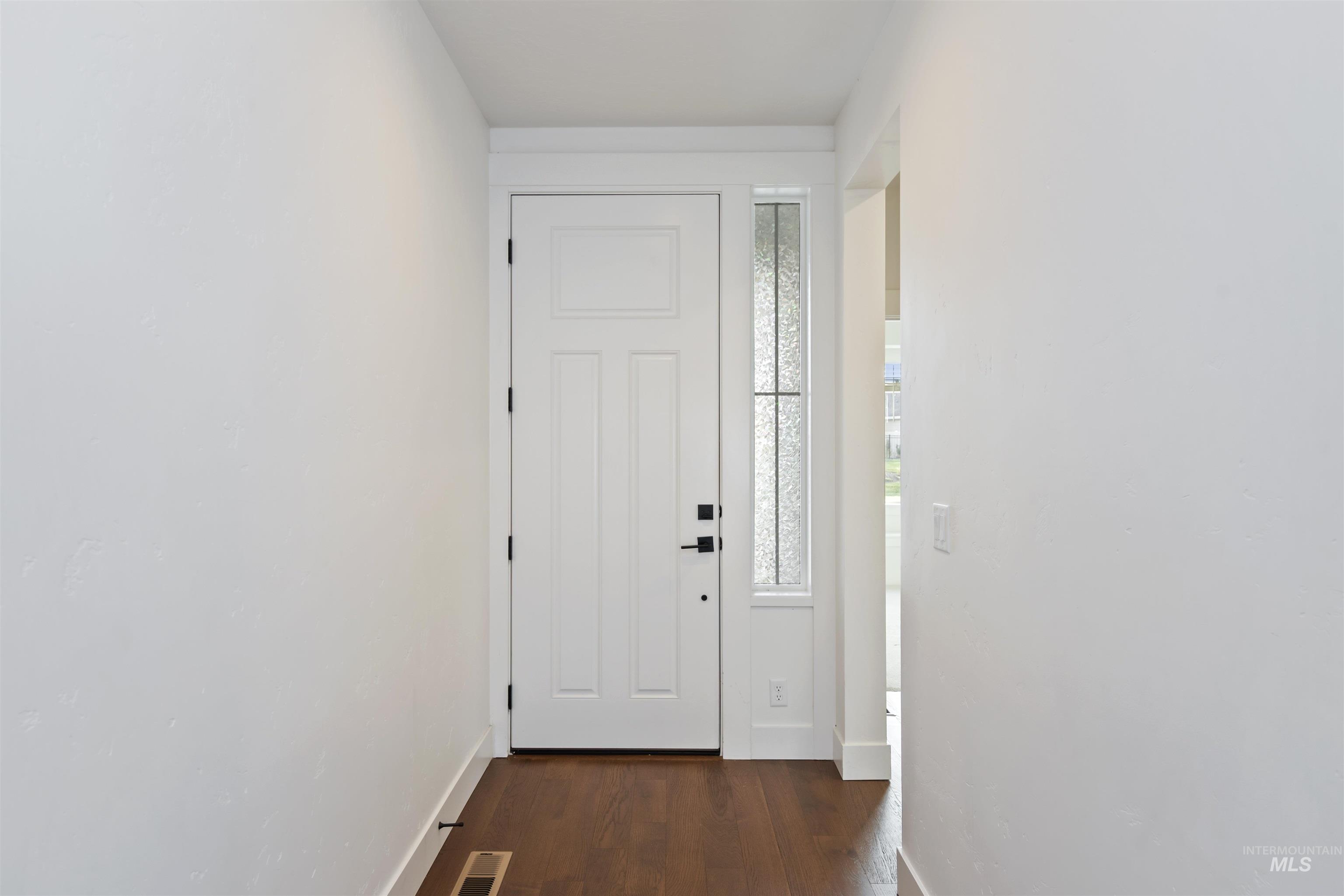 Doorway to outside with wood finished floors and baseboards