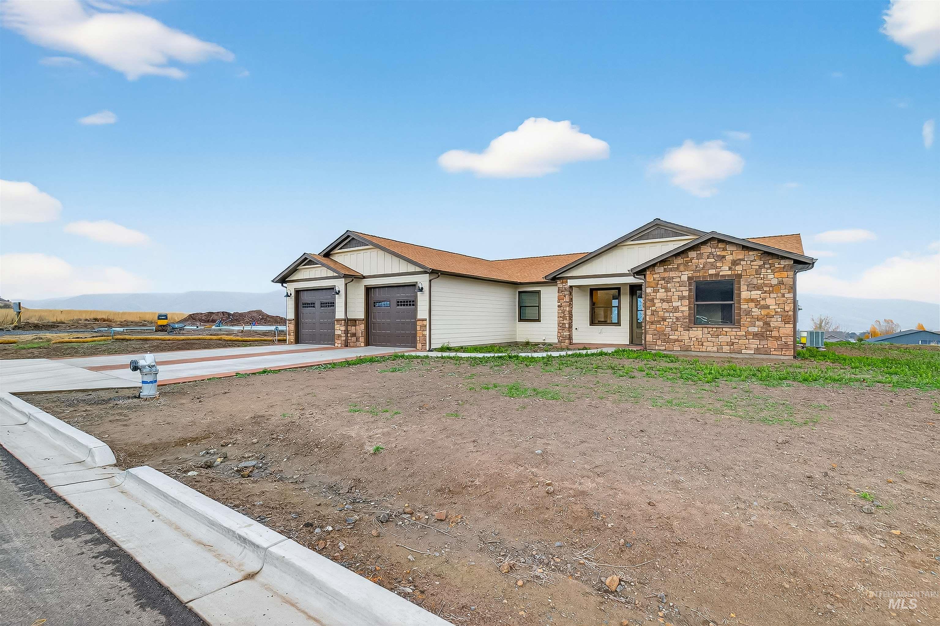 View of front of house with stone siding, concrete driveway, a garage, and board and batten siding