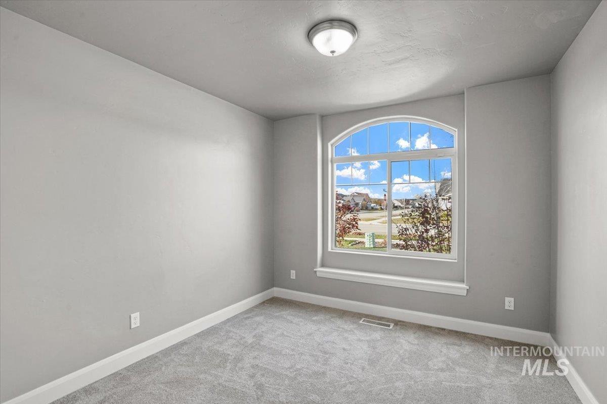 Unfurnished room featuring light colored carpet and baseboards