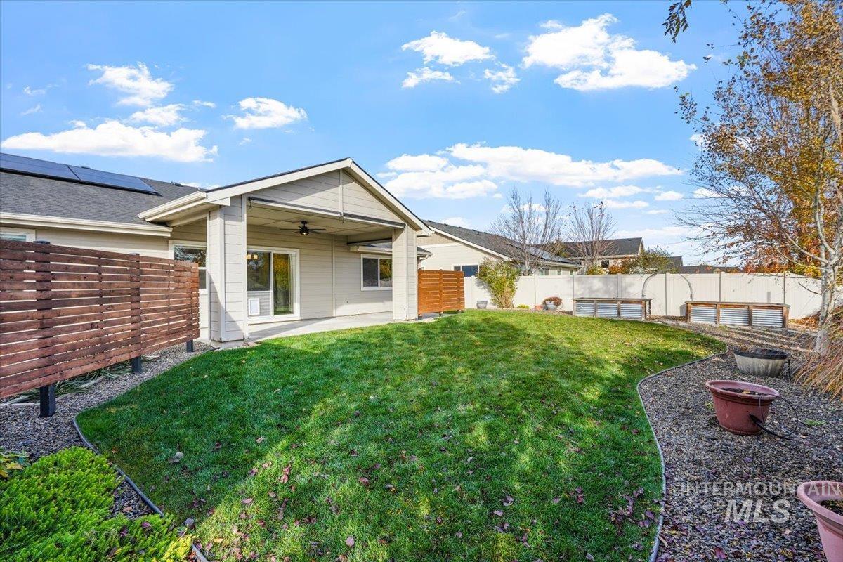 Rear view of property with ceiling fan, a patio area, and a fenced backyard